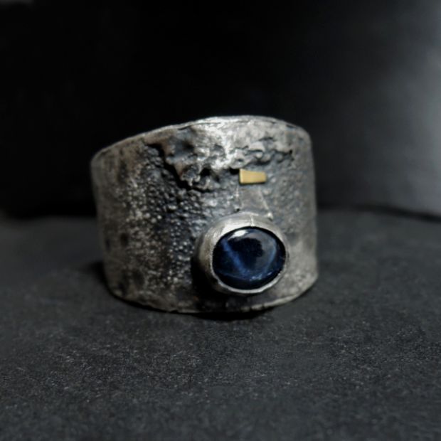 duży srebrny pierścień z szafirem gwiaździstym i złotem